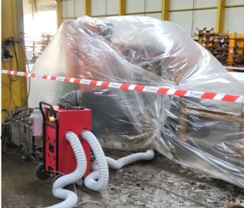 Assécheur rouge raccordé à un équipement industriel protégé par un film