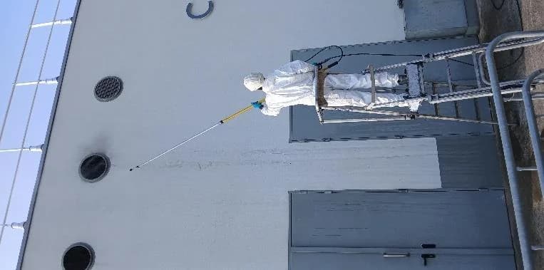 Technicien décontaminant la façade de l'immeuble