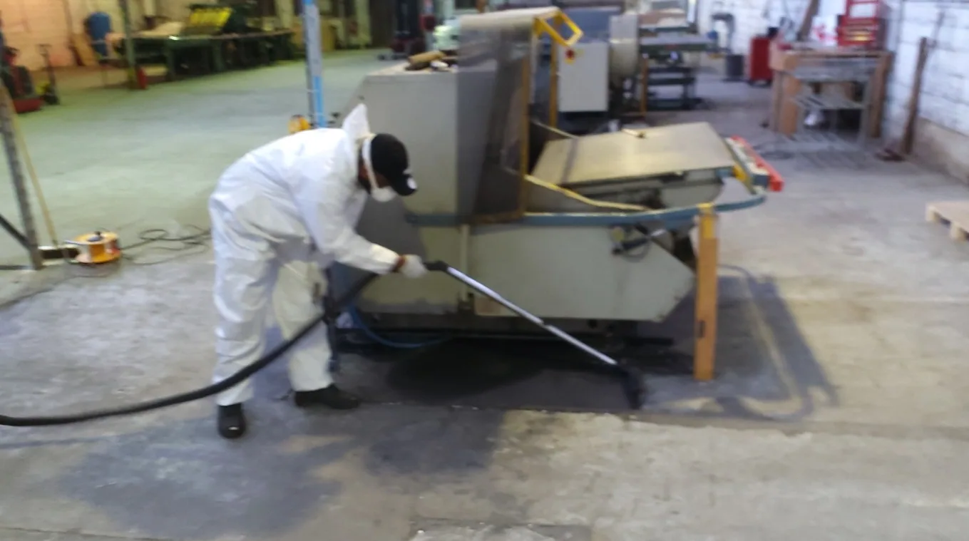 Technicien nettoyant une machine industrielle à l’aide d’une lance