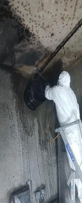 Technicien inspectant le local TGBT avant décontamination